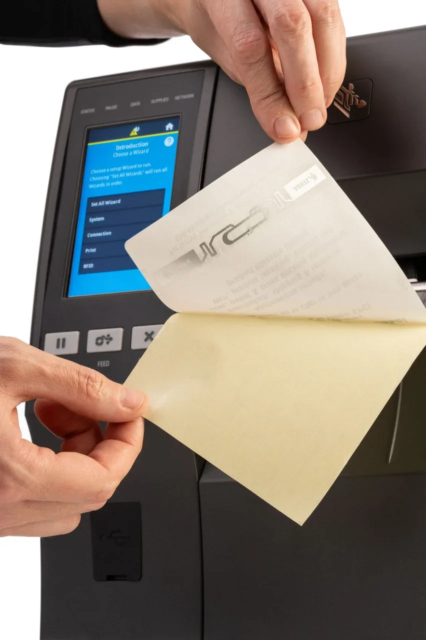Etiqueta RFID UHF recién impresa, con el inlay visible al trasluz