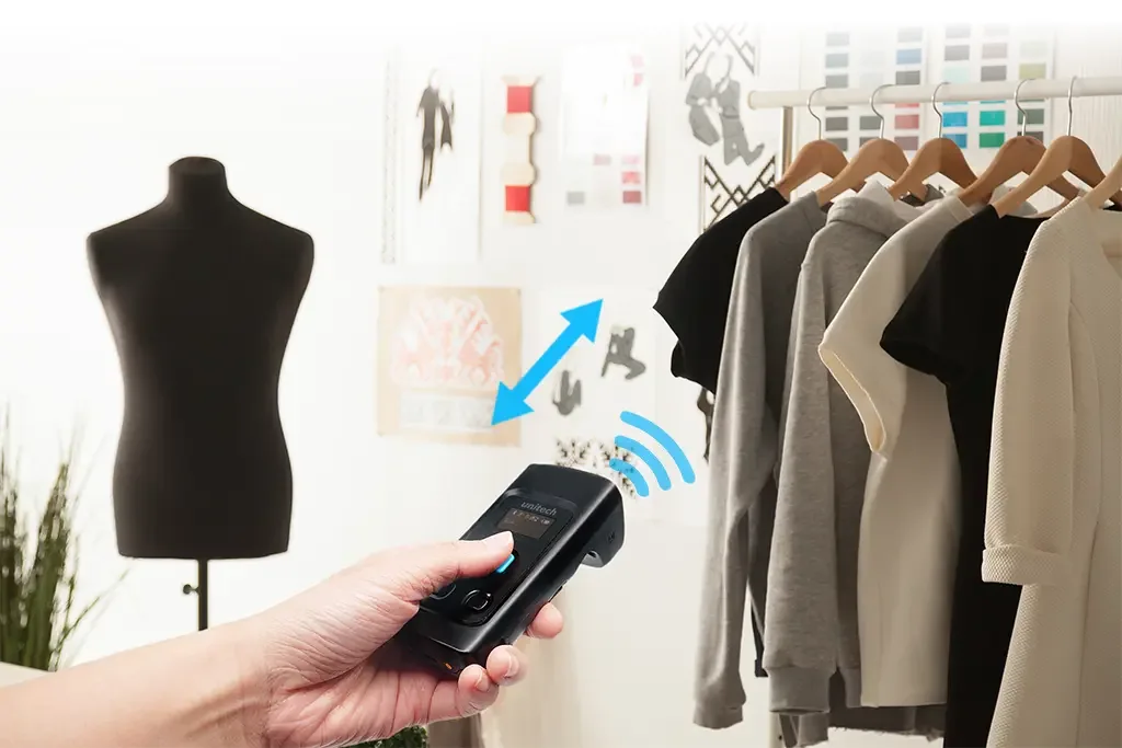 Lector RFID Unitech RP902 de bolsillo leyendo prendas colgadas en una tienda
